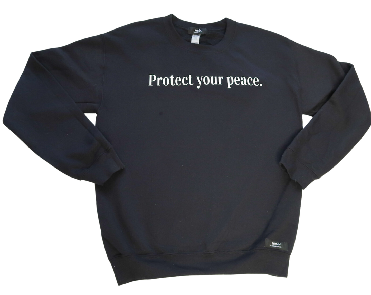 Long sleeve cozy black colored crewneck sweater with white vinyl lettering with phrase “Protect your peace.”