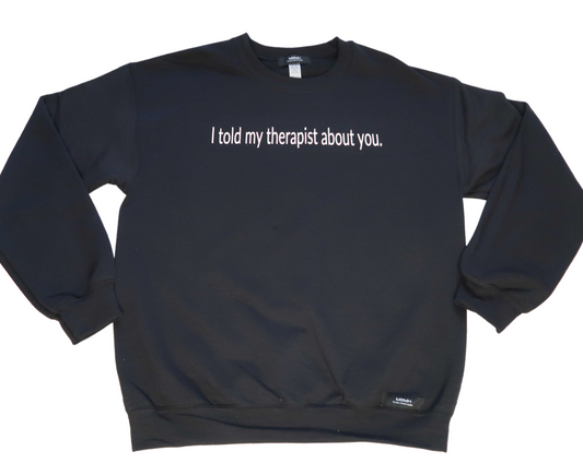 Long sleeve cozy black colored crewneck sweater with white vinyl lettering with phrase “I told my therapist about you”