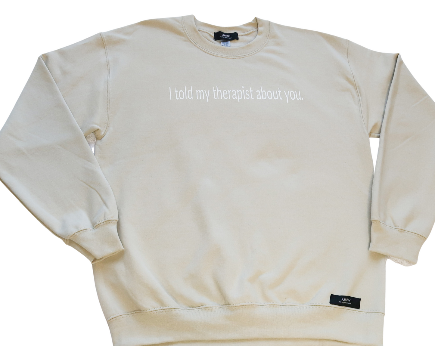 Long sleeve cozy sand colored crewneck sweater with white vinyl lettering with phrase “I told my therapist about you”